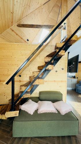 a bed in a room under a wooden stairs at Complex A Toplita in Topliţa