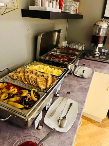 a kitchen with many trays of food on a counter at VICI Hotels Linköping in Linköping