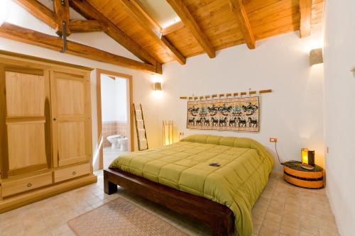 una camera con letto e soffitto in legno di B&B Stentadì a Quartucciu