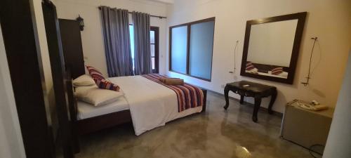 a hotel room with a bed and a mirror at VillaWatuna in Unawatuna