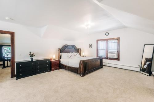 a bedroom with a bed and a dresser and a window at Minnehaha Falls Hideaway in Minneapolis
