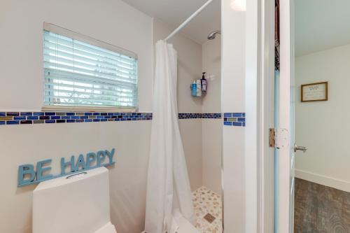 a bathroom with a shower and a toilet and a window at Waterfront Home with Private Hot Tub in Tavernier! in Tavernier