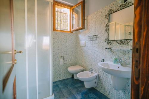 a bathroom with a sink and a toilet and a mirror at Agriturismo Angeli Sognanti in Cossignano
