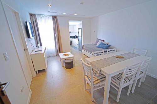 un salon avec une table blanche et un canapé dans l'établissement NOR 404 - Departamento de categoría con hermosas vistas, à Ushuaia