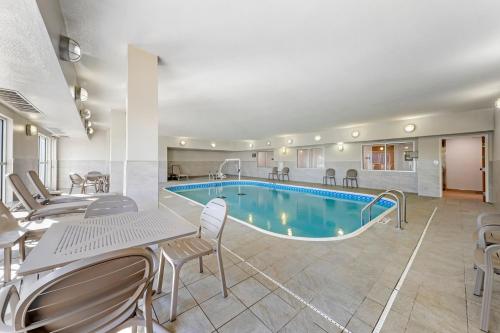 a pool in a hotel room with chairs and a table at Comfort Inn & Suites Oklahoma City North - Quail Springs in Oklahoma City