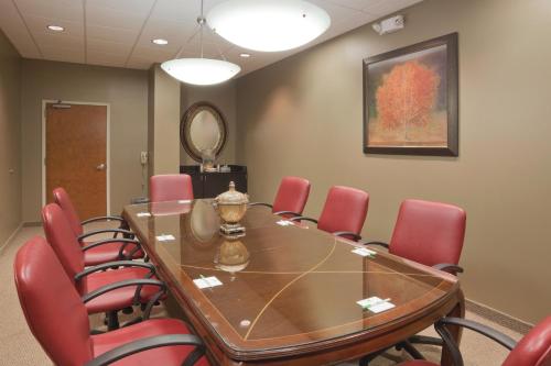 a conference room with a table and red chairs at Holiday Inn Carbondale - Conference Center by IHG in Carbondale