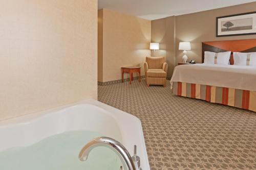 a bathroom with a tub and a bedroom with a bed at Holiday Inn Carbondale - Conference Center by IHG in Carbondale