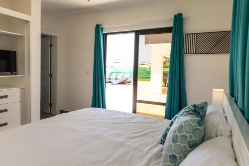 een slaapkamer met een bed en een glazen schuifdeur bij Casa De lo Mio in Sosúa