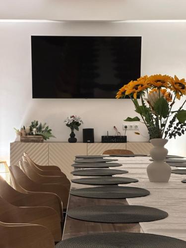 a long row of chairs and a table with flowers at Casa David Valea Avrigului in Avrig