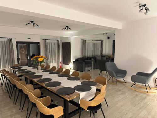 a long table and chairs in a room at Casa David Valea Avrigului in Avrig