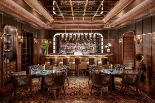 a restaurant with tables and chairs and a bar at InterContinental Bangkok Sukhumvit by IHG in Bangkok