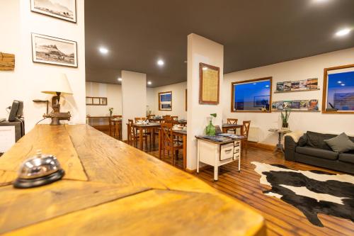 a living room with a large wooden table in it at Pristine Patagonia Hotel in Puerto Natales
