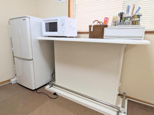 a kitchen counter with a microwave and a refrigerator at Minpaku ROADHOUSE - Vacation STAY 20160v in Nagasaki