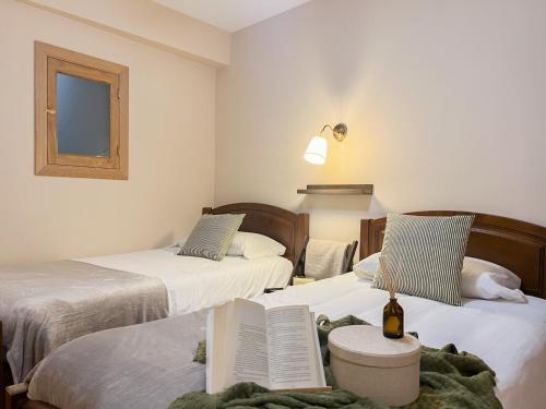 a room with two beds with a book on a table at Alojamientos Abuelo Teófilo - Valle del jerte in Tornavacas