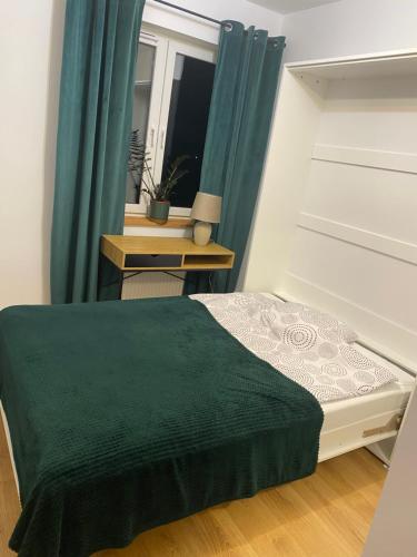 Un pequeño dormitorio con una cama y una mesa. en Sowa, en Lipno