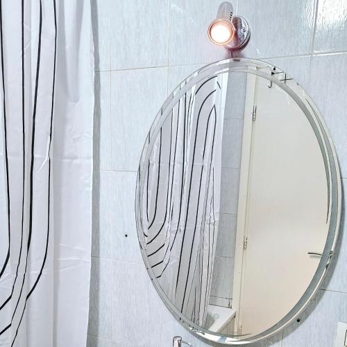 a mirror in a bathroom with a light on it at Tirana Center - AAL in Tirana