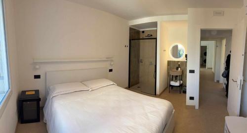 a bedroom with a white bed and a hallway at Villa San Biagio Residence in Mason Vicentino