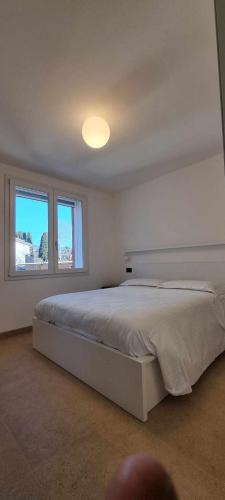 a white bedroom with a large bed and a window at Villa San Biagio Residence in Mason Vicentino