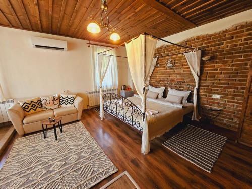 a living room with a bed and a couch at Панорама хаус Лещен и еко къщи Дървена и Землянка in Leshten