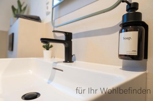 a bottle of soap sitting on top of a bathroom sink at Eifel-Auszeit Komfort & Stil G128 in Euskirchen