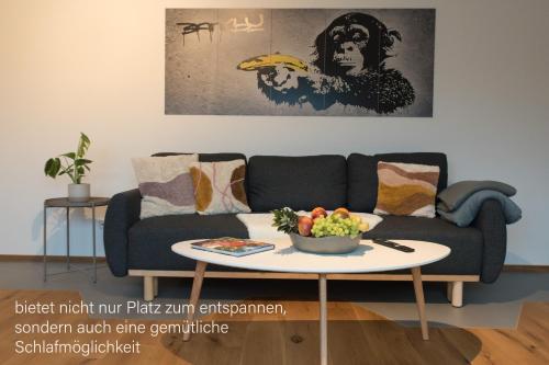 a living room with a couch and a table with a bowl of fruit at Eifel-Auszeit Komfort & Stil G128 in Euskirchen