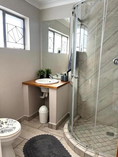 un baño con ducha y lavabo en Just Stay, en Bloemfontein