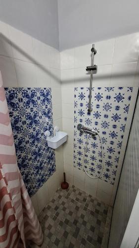 a bathroom with a shower with blue and white tiles at Dar Janis Djerba دار يانيس جربة in Houmt Souk