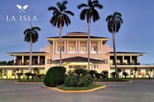 a building with palm trees in front of it at LA ISLA RESIDENCES, DEPA DE LUJO, Acapulco Diamante in Acapulco