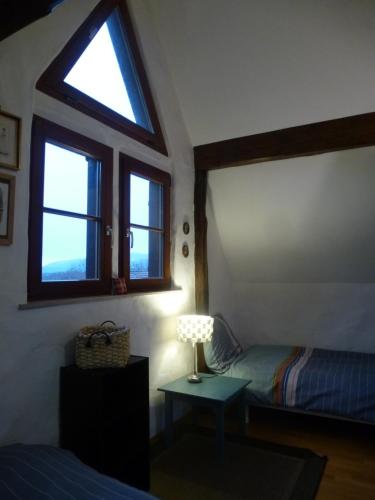 a bedroom with a bed and a table with a lamp at La Pomme de Pin in Raedersdorf