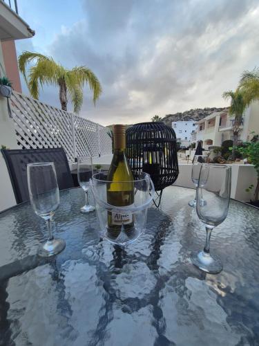 a bottle of wine sitting on a table with two wine glasses at 2 bedroom townhouse lower peyia paphos Cyprus in Peyia