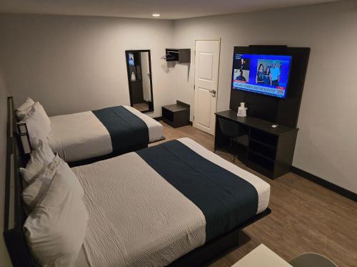 a hotel room with two beds and a flat screen tv at Motel 6 Los Angeles, CA - Downtown in Los Angeles