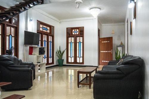 a living room with two couches and a tv at Sun Shades View Residence in Andugoda