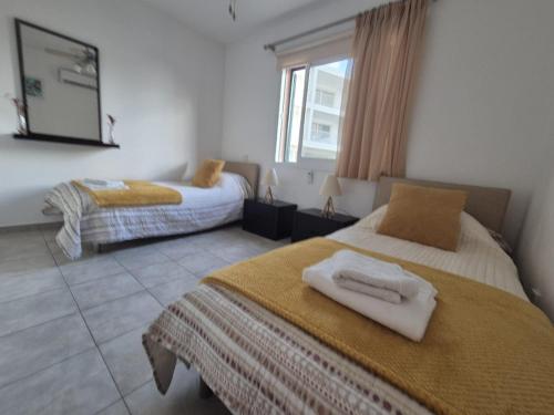 a bedroom with two beds with towels on them at 2 bedroom townhouse lower peyia paphos Cyprus in Peyia