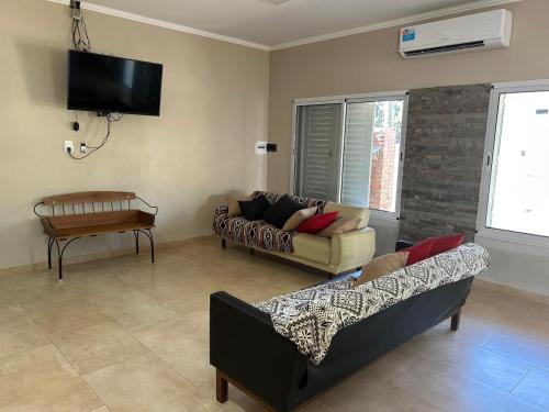 a living room with two couches and a flat screen tv at Casa Quinta Los Arandanos in San Geronimo