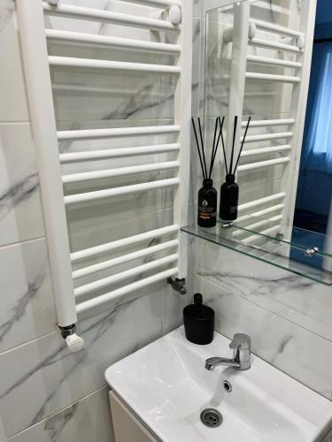 a white bathroom with a sink and a mirror at The Salin Spot in Turda