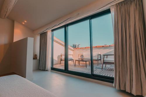 a bedroom with a large window with a view of a patio at Maison Galante au Vieux Port in Marseille