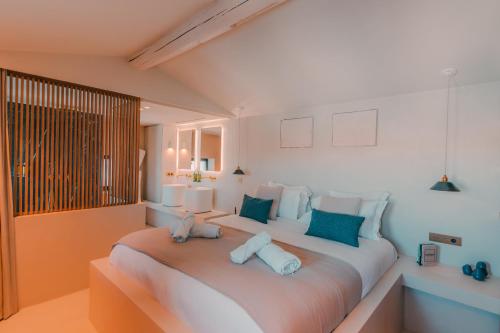 une chambre avec un grand lit blanc avec des oreillers bleus dans l'établissement Maison Galante au Vieux Port, à Marseille