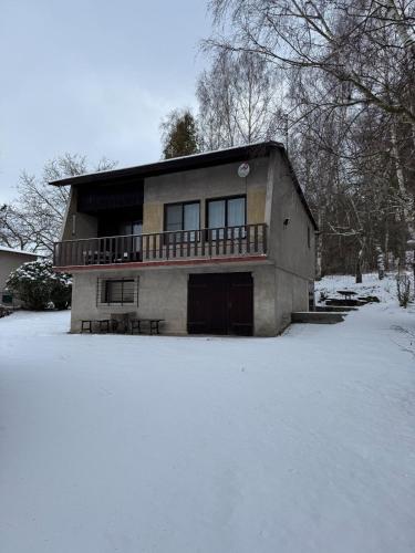 a house with a balcony in the snow at Dům v přirodě in Vilice