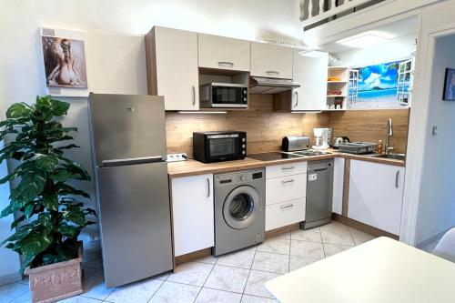 une cuisine avec un réfrigérateur et une machine à laver dans l'établissement Naturiste Cap d'Agde Villa Héliovillage 12, au Cap d'Agde