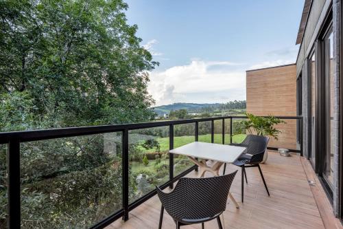 a balcony with a table and chairs on a building at Olive Living Suites by HOUSY HOST in Envigado
