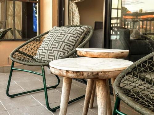 a pair of chairs and a table on a porch at Zimbali Suite 512 in Ballito