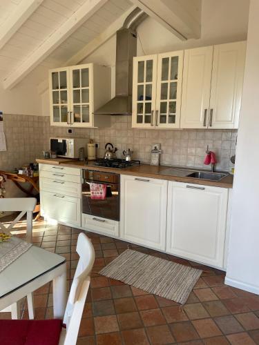 a kitchen with white cabinets and a stove top oven at como tavernerio shabby chic bilocale zero smog in Tavernerio