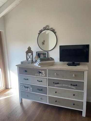 a dresser with a flat screen tv and a mirror at como tavernerio shabby chic bilocale zero smog in Tavernerio