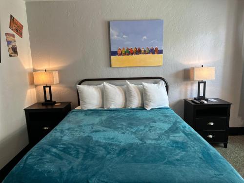 a bed in a hotel room with two lamps at Sea Jay Motel and Marina in St Pete Beach