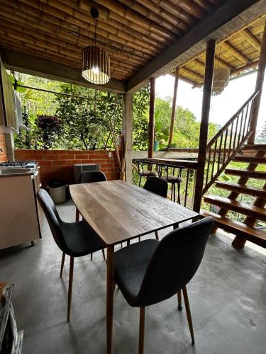 a wooden table and chairs on a patio at Cabaña campestre para parejas o grupos in Manizales
