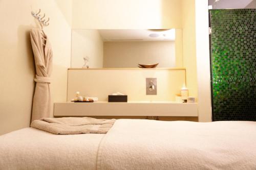 a bedroom with a white bed and a mirror at Noom Hotel Abidjan Plateau in Abidjan