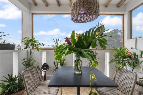 a table with chairs and a vase with plants on it at Loft Ecochic in Isla Mujeres