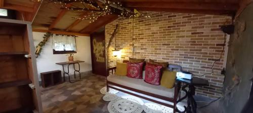 a room with a brick wall and a bench with pillows at Bohemio Chic House - Alojamiento con vista al bosque a 45 minutos de Medellin en Santa Elena in Santa Elena