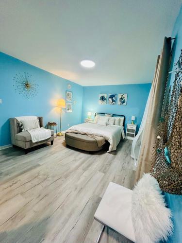 a bedroom with blue walls and a bed and a couch at Coastal Retreat Near Pineville and CLT in Charlotte