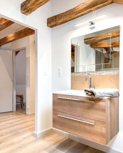 une salle de bain avec un lavabo et un miroir dans l'établissement Domaine des 5M, Authenticité et Élégance au cœur du Cantal, à Velzic